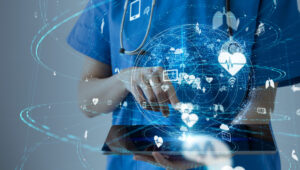 healthcare technology concept (with nurse holding a tablet and technology icons floating around it)